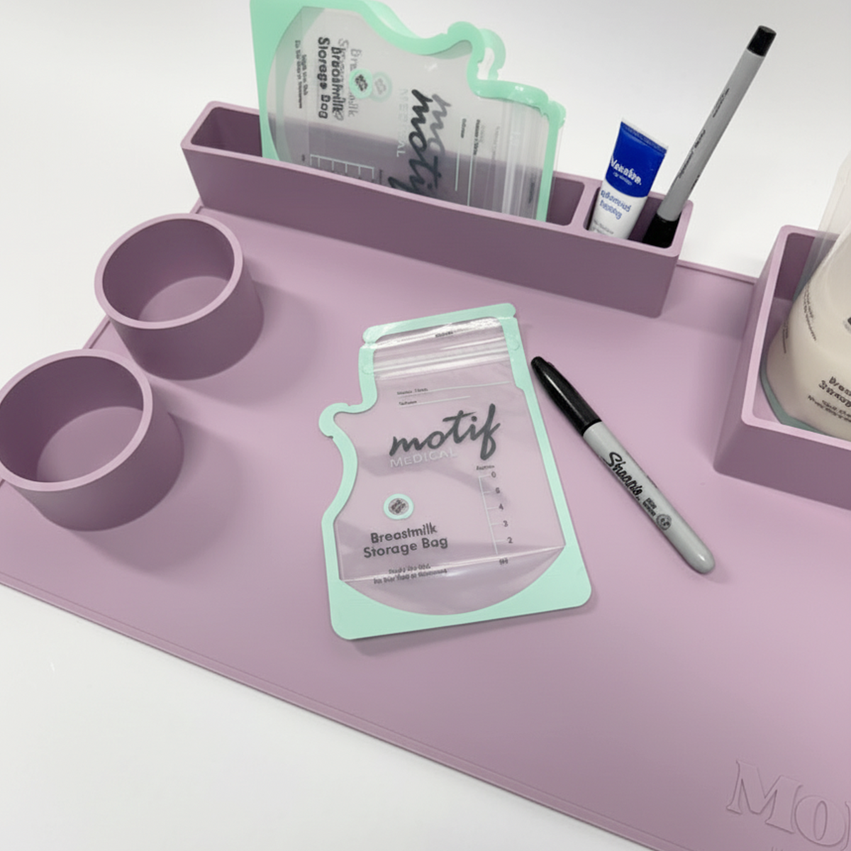 Close-up of MoJo mat compartments with embossed MoJo Lactation Co. logo and breastmilk storage bag