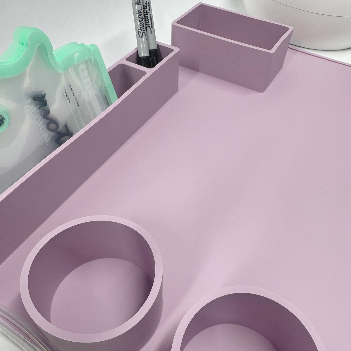 MoJo mat compartments holding a Motif breastmilk storage bag, nipple cream, and marker